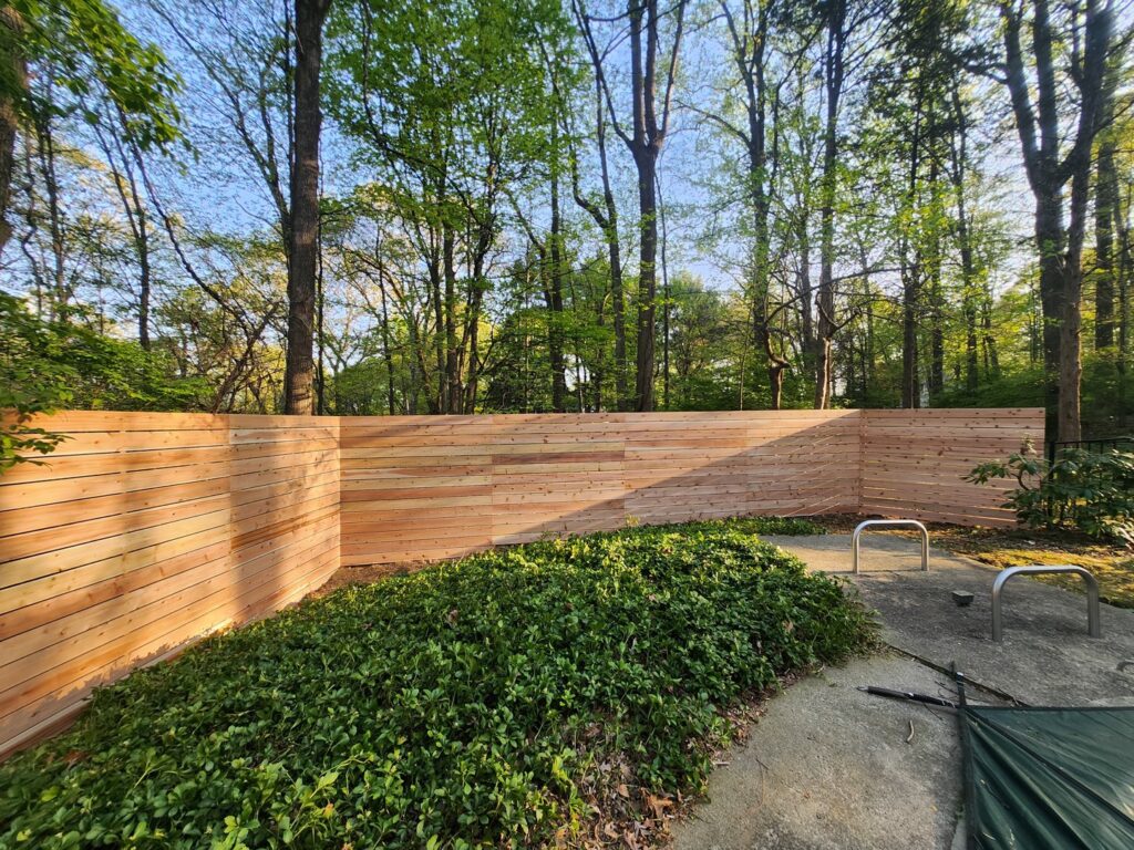 A newly installed horizontal slat wooden fence providing privacy in a residential backyard by H&M Fence, LLC in Norwalk, CT.