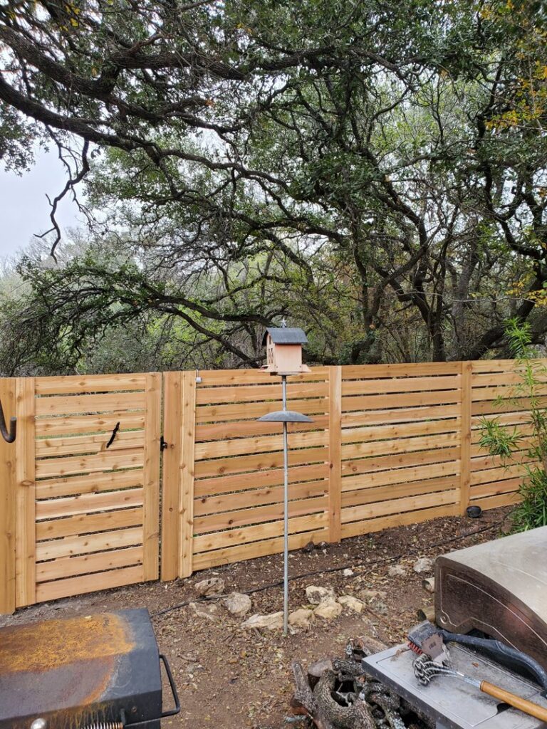 A modern horizontal slat wood fence with a matching gate installed by City Fence Co of San Antonio, TX