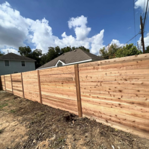 A modern horizontal slat wood privacy fence installed along a property line by K.K. Landscaping & Fencing in Austin, TX.
