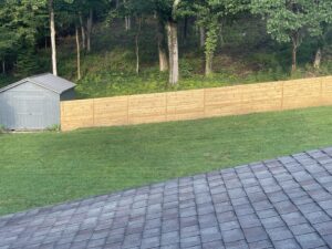 A horizontal slat wooden fence installed next to a backyard shed, viewed from an elevated position, by Fenceworks of Middle Tennessee in Nashville, TN.