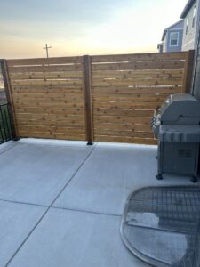 A modern horizontal slat wooden privacy fence installed on a patio, showcasing work by North CO Fence & Deck in Greeley, CO.