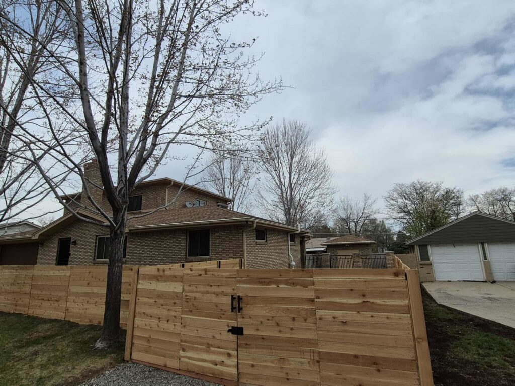 A newly installed horizontal wood fence with a gate by Supreme Fencing Denver, CO.