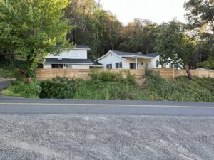 A horizontal slat wood fence installed along a hillside property by Prestige Fencing LLC in Medford, OR.