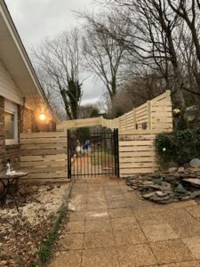 A horizontal wood fence with a black metal gate installed by Escamilla Fence Co. in Knoxville, TN