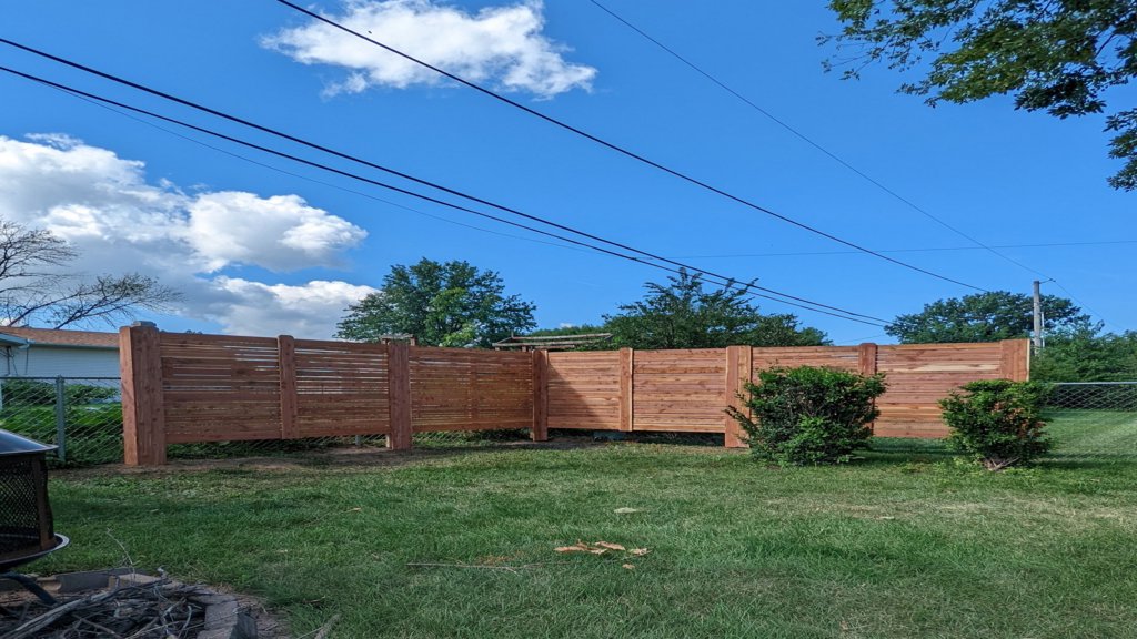 A newly installed horizontal wood privacy fence in a residential backyard by Corridor Residential Fencing Co. in Cedar Rapids, IA.