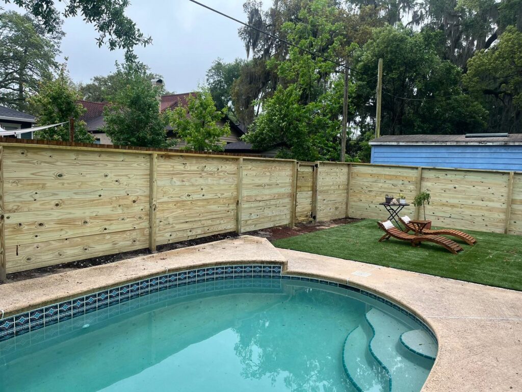 A modern horizontal wood privacy fence enclosing a swimming pool area, installed by Exacta FENCE LLC in Jacksonville, FL.