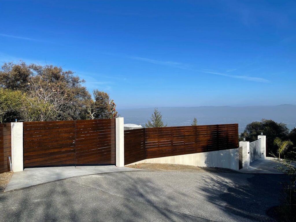 A modern horizontal wood slat fence with concrete posts by Jaz Builders Inc in Santa Clara, CA.