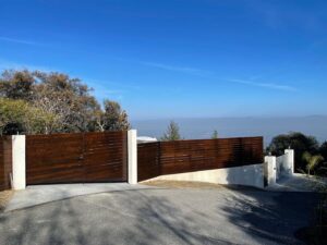 A modern horizontal wood slat fence with concrete posts by Jaz Builders Inc in Santa Clara, CA.