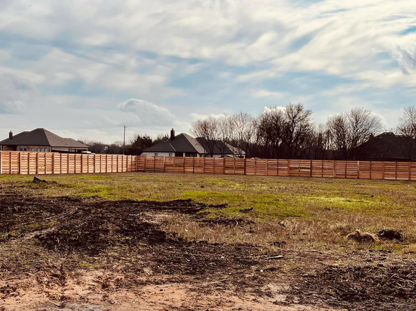 Horizontal wood slat fence installation in a large open area by Plano Fence and Arbor Pro in Plano, TX.
