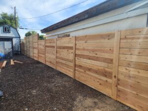 A newly installed horizontal wood slat fence next to a residential building by Josey's Fencing LLC in Caldwell, ID.