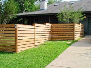 A modern horizontal wood slat fence enclosing a residential property, installed by Ozark Fence in Lakewood, CO.