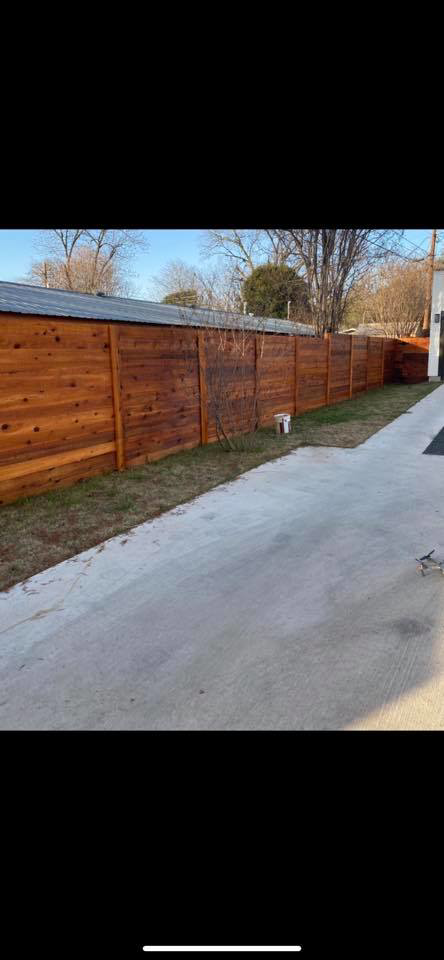 A newly installed horizontal wooden fence running alongside a concrete path by G Squared Fencing & Services LLC in New Braunfels, TX.