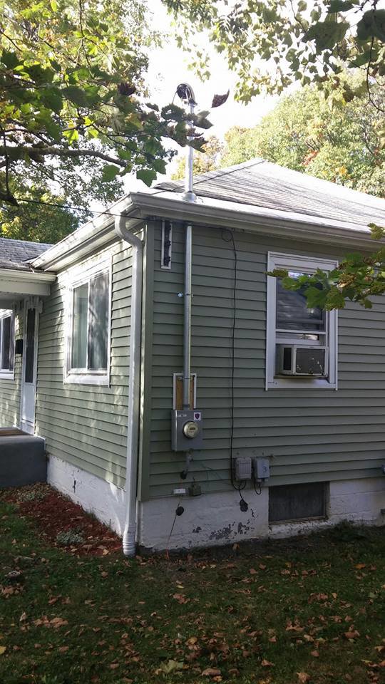 Exterior view of a house showing electrical service entrance and conduits installed by Dragons Electric in Schenectady, NY