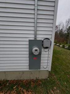 A complete exterior electrical service setup with meter and panel installed by IN Power Electric in Gorham, ME