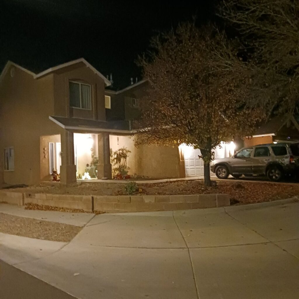 A residential house at night, brightly lit by outdoor electrical fixtures installed by Calhoun Electric Inc. in Rio Rancho, NM