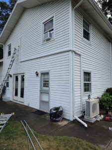 Exterior of a house showing a Mitsubishi HVAC unit installation in progress by KO HVAC Heating & Cooling in Kingston, PA.