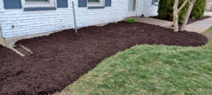 Extensive dark mulch applied along the foundation of a house by VKDYS Lawn Care in Fort Wayne, IN.