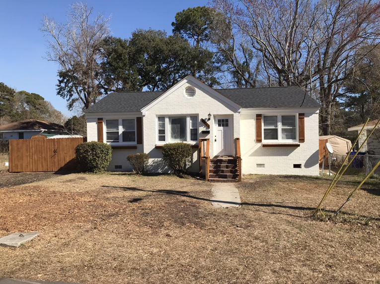 A front view of a residential house with a newly installed wooden fence on the left side by Lundquist Home Improvements in Mount Pleasant, SC.