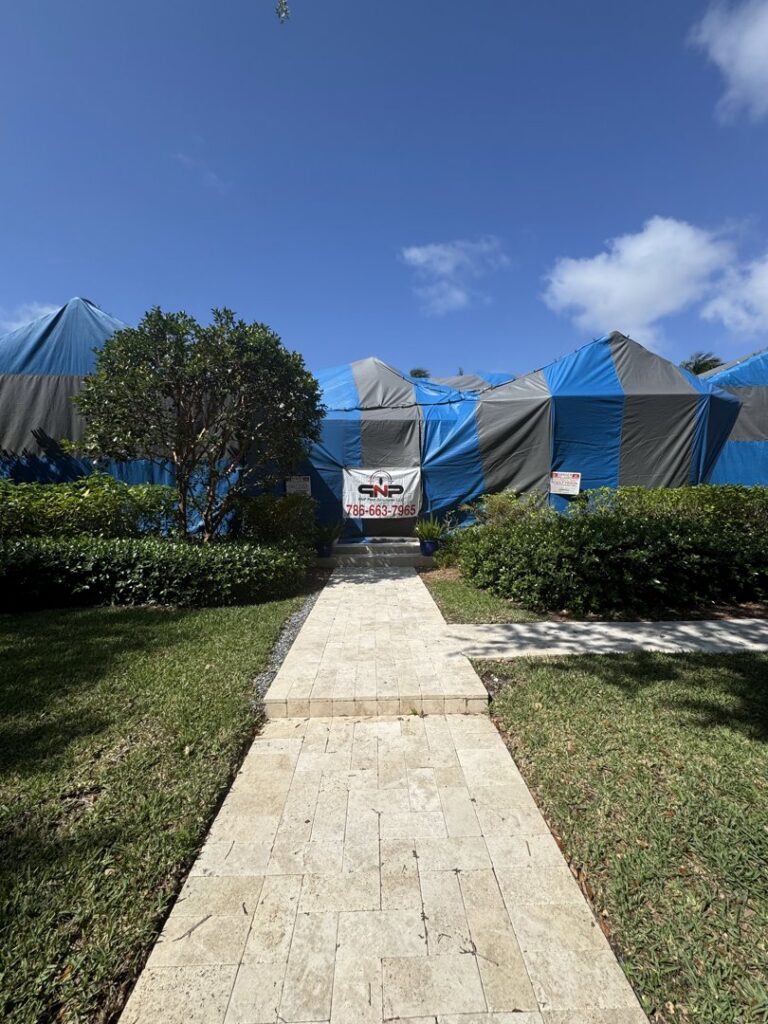 A house covered in a blue and grey fumigation tent by PNP Pest Solutions LLC in Miami, FL.