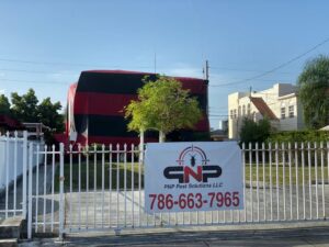A house covered in a red and black fumigation tent by PNP Pest Solutions LLC in Miami, FL.