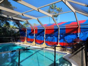 A house tented for pest control, viewed from a poolside area, by Monster Pest Control in Miami, FL.