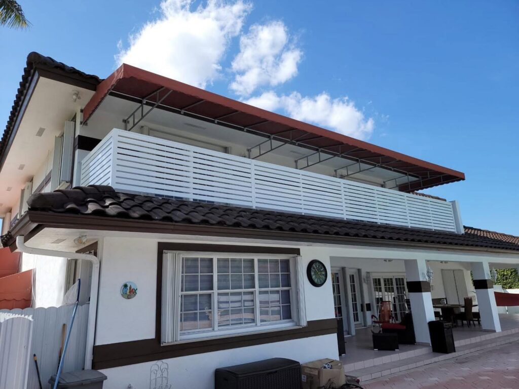A house featuring a white slatted balcony fence installed by Osuna Ornamental Fences & Gates in Cutler Bay, FL.