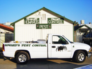 A white Howard's Pest Control truck with a spider graphic and pest control equipment in Fresno, CA.