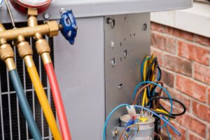 Close-up of electrical components and wiring inside an outdoor AC unit during repair by Wyles Heating & Air Conditioning Inc. in North Canton, OH.