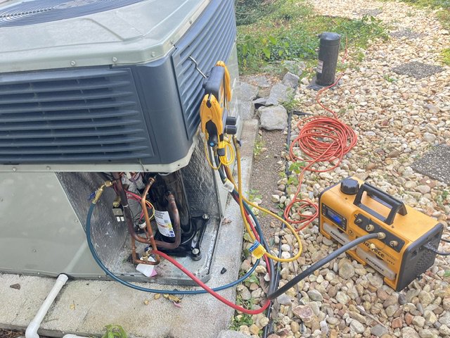 An HVAC technician performing maintenance or repair on an AC unit for CHIN Flower HVAC LLC in Murfreesboro, TN.