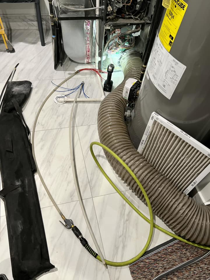 Air duct cleaning equipment connected to a residential HVAC system and water heater during a service by Air Duct Docs in Norridge, IL