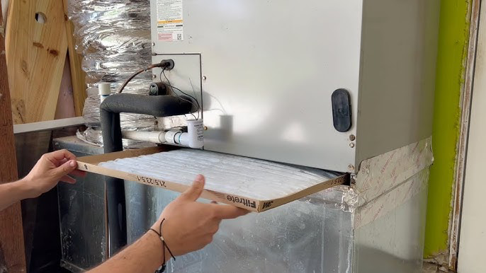 Hands replacing an air filter in an indoor HVAC unit by Elite Air and Heat of Summerville, SC.