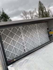Clean air filters inside a commercial rooftop HVAC unit during maintenance by Heatwave Heating & Air LLC in Federal Way, WA.
