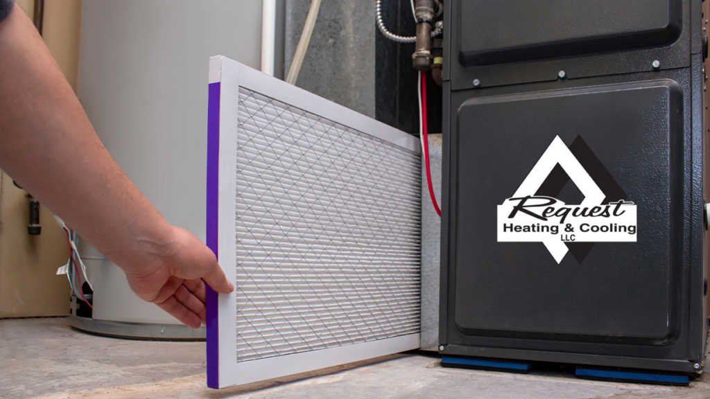 A technician replacing a dirty air filter in a furnace or air handler, a service provided by Request Heating & Cooling in Holland, MI
