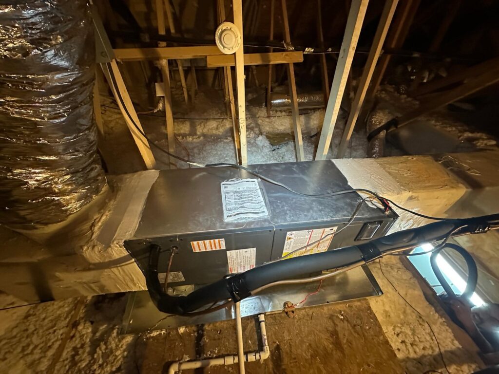 An HVAC air handler unit installed in an attic with visible ductwork, a service provided by Air Casablanca Heating & Cooling in Myrtle Beach, SC.
