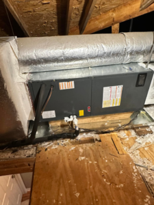 An indoor HVAC air handler unit with ductwork installed in an attic by Barnie Sales Heating & A/C in Mobile, AL