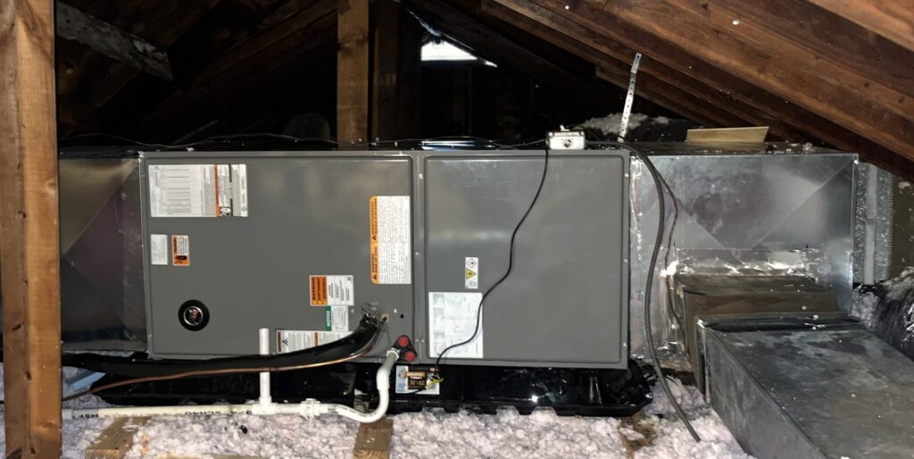 An HVAC air handler unit installed in an attic with insulation and ductwork by DND Mechanical in Columbus, OH.