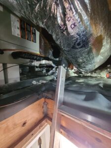 View into an attic showing an HVAC air handler and ductwork installation by Rivertech Heating & Air Conditioning in Chattanooga, TN.