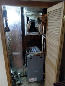 An indoor HVAC air handler unit undergoing repair or replacement in a closet by Global Sheetmetal Inc in Warwick, RI.