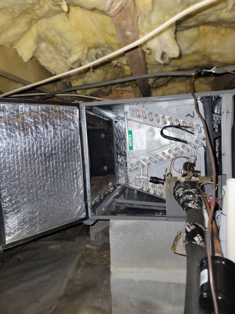 An open indoor HVAC air handler unit showing coils during service by Comfort Hounds Heating & Cooling in Raleigh, NC.