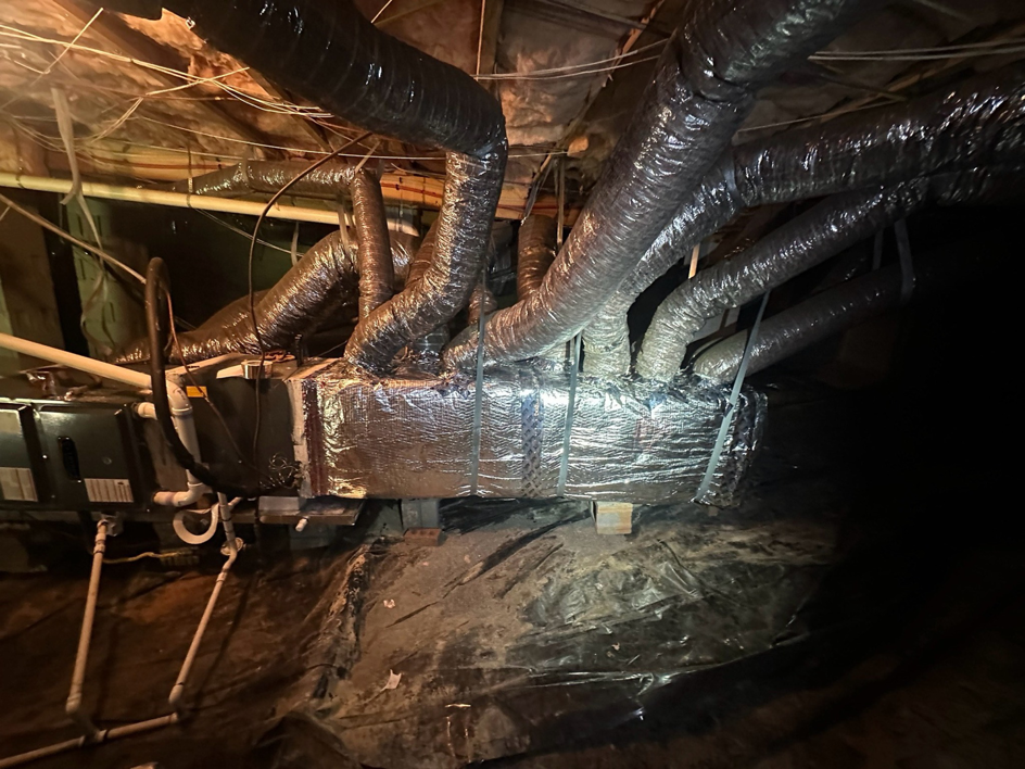 An HVAC air handler unit with flexible ductwork installed in a crawl space by Arctic Desert Cooling & Heating in Concord, NC