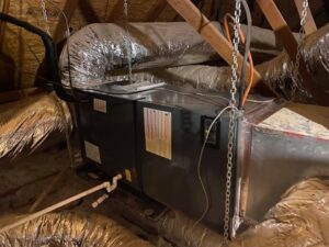 An HVAC air handler unit and ductwork installed in an attic, representing services from Full Send Plumbing Heating & Cooling in Stillwater, OK.