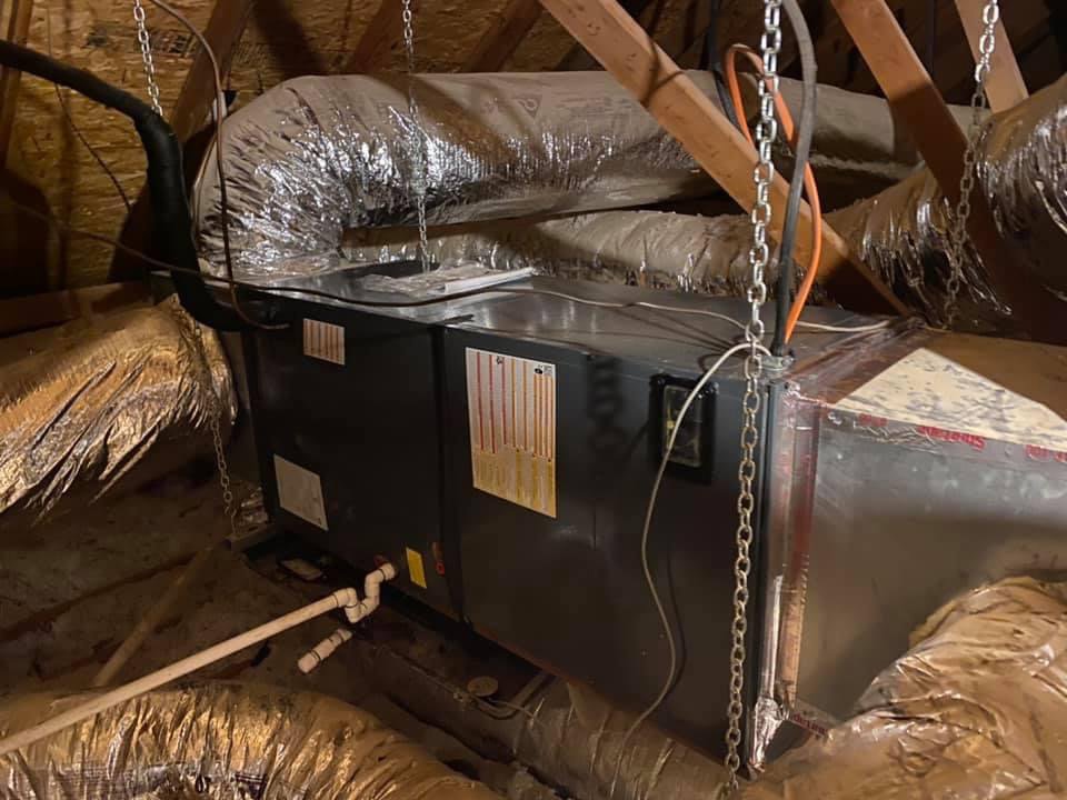 An HVAC air handler unit and ductwork installed in an attic, representing services from Full Send Plumbing Heating & Cooling in Stillwater, OK.