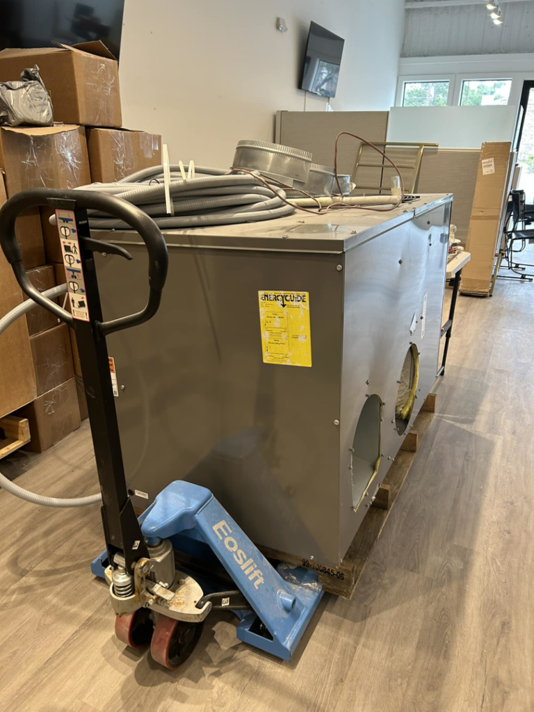 An HVAC air handler unit on a pallet jack with ductwork components, prepared for installation by HP Mechanical LLC in Santa Rosa, CA.
