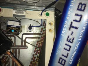 Inside an HVAC air handler showing coils, wiring, and a newly installed germicidal UV light by West Tennessee Heat & Air in Memphis, TN