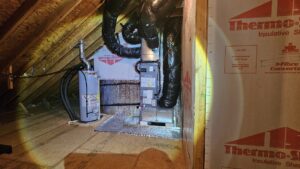An HVAC air handler and water heater installed in an attic space by Peak Seasons HVAC in Raleigh, NC.