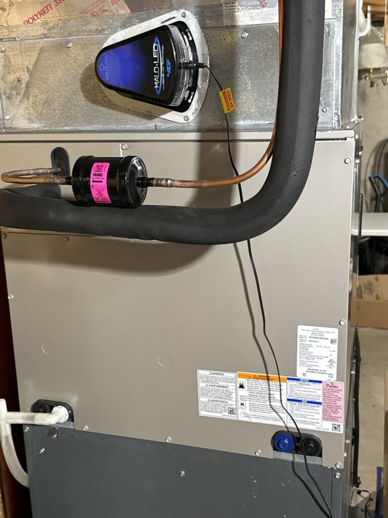 An HVAC unit with a HALO LED air purifier and electrical wiring serviced by Kelly Heating & Electric, LLC in Eau Claire, WI.