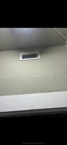A white HVAC air vent or register installed on a wall, part of a system by Air Advisors of Louisiana in Shreveport, LA.