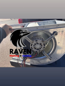 An HVAC technician holding a blower motor assembly for replacement by Raven Heating & Cooling in El Paso, TX.