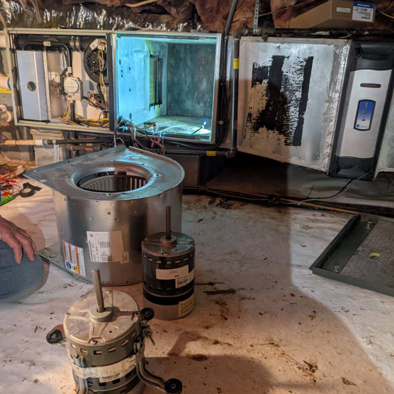 New and old HVAC blower motors and components on the floor during a repair by Speedy Nelson HVAC Repair in Durham, NC.