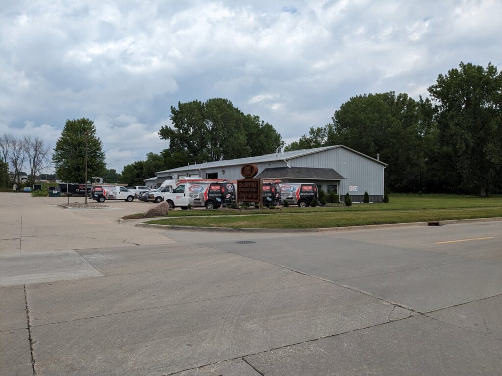The exterior of Marie Keding Bryant Iowa Heating and Cooling business with multiple service vans parked in Ankeny, IA.